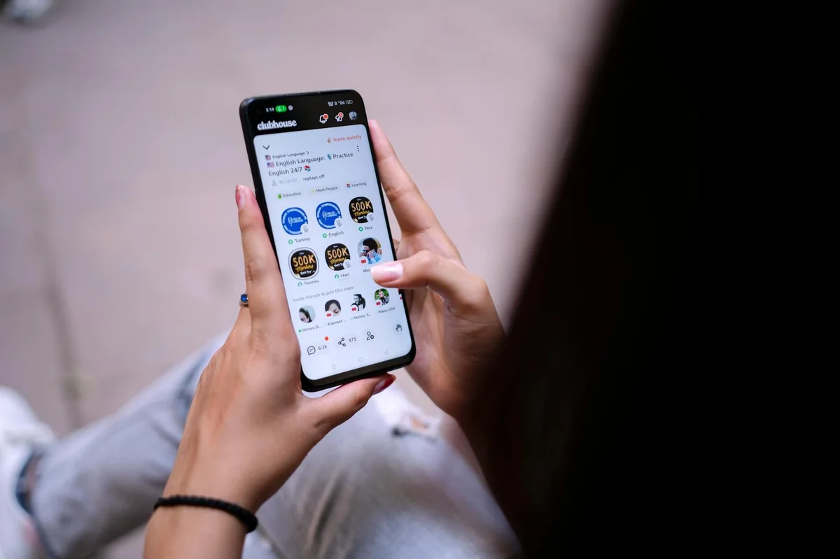 Cómo usar TikTok en 2026: guía paso a paso para principiante... — Close-up of a woman using a smartphone with social media app open. Hands holding