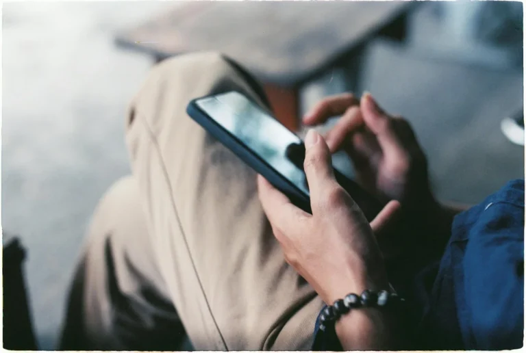 Cómo leer las estadísticas de TikTok: tutorial de analítica... — A close-up view of a person using a smartphone indoors, showcasing modern techno