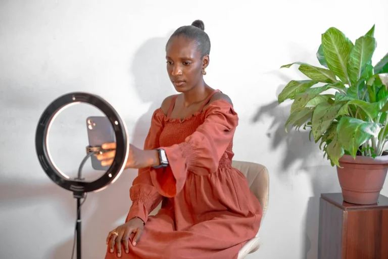 Cómo elegir el formato de contenido correcto en TikTok: tuto... — A young woman uses a smartphone ring light setup for vlogging from home.