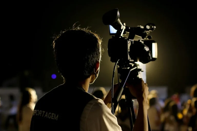 How to Build a Recognizable Brand on TikTok: Step-by-Step Tu... — A cameraman filming an event outdoors at night with professional equipment, capt