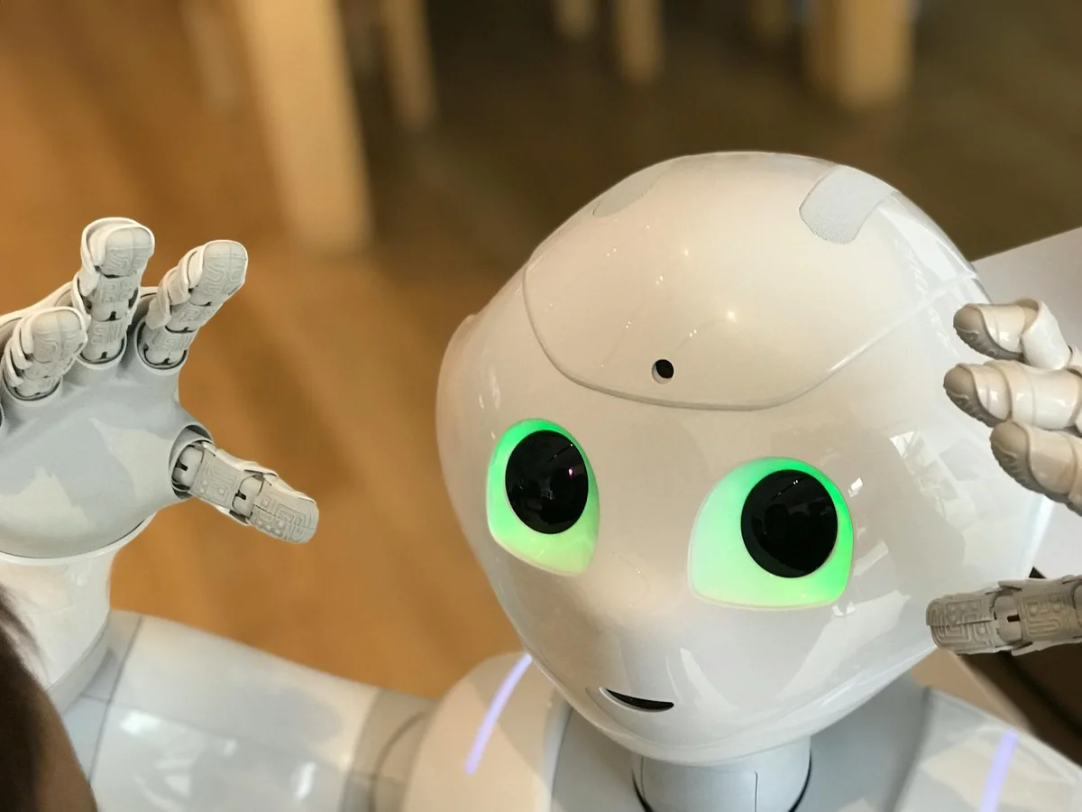 Cómo crear un manual de estilo para que la IA escriba como t... — A futuristic humanoid robot with glowing green eyes in a modern setting.
