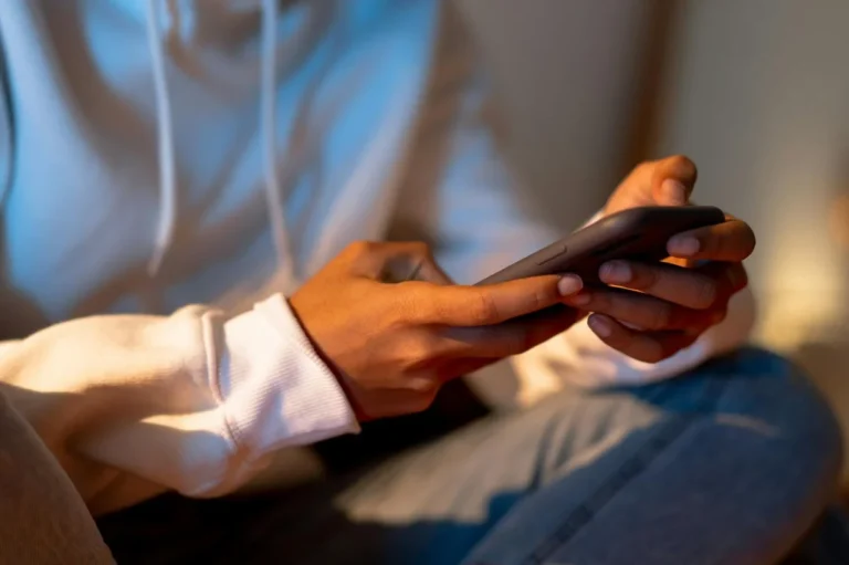 How to Sell on TikTok Without Looking Like You're Selling: S... — Close-up of a person holding a smartphone indoors, emphasizing digital interacti