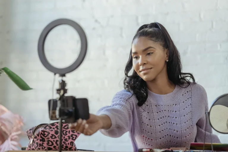 How to Keep Viewers Watching on TikTok: A Psychology-Based T... — Glad African American female blogger with long dark hair using mobile phone and