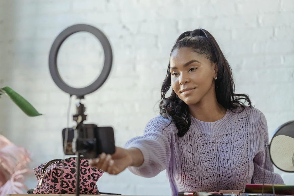 How to Keep Viewers Watching on TikTok: A Psychology-Based T... — Glad African American female blogger with long dark hair using mobile phone and