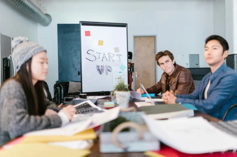 Cómo iterar con Claude: tutorial de feedback para mejorar re... — A group of young professionals brainstorming ideas in a startup office setting.