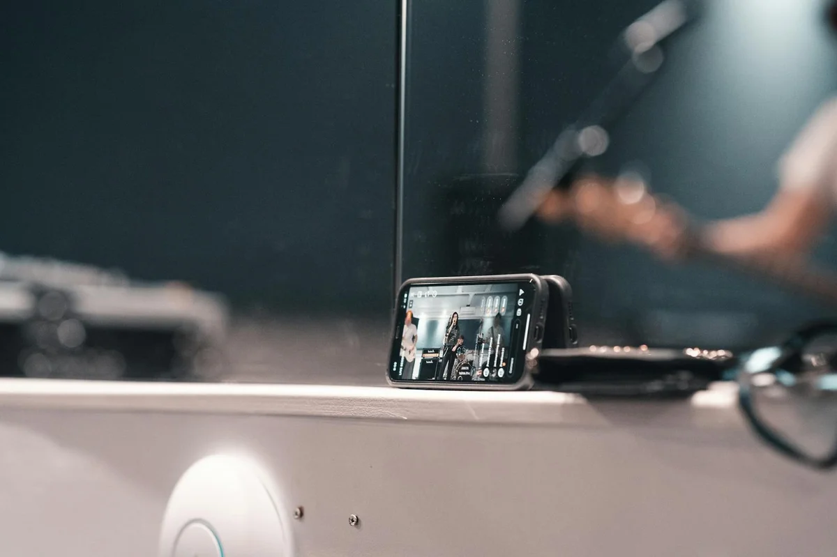 Cómo captar y mantener la atención en TikTok: tutorial de ps... — A smartphone recording a live band performance at an indoor event.