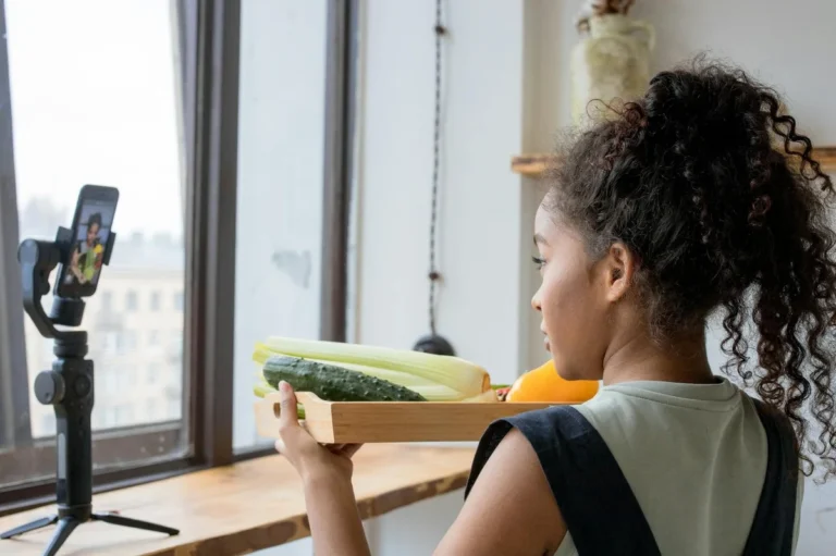 How to Turn TikTok Into a Real Business: Creator Models That... — A young woman vlogging her healthy cooking session using a smartphone indoors.