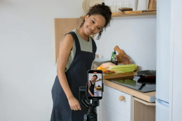 Por que no puedes concentrarte (y como solucionarlo sin deja — Smiling young woman films a cooking video at home using a smartphone in her kitc