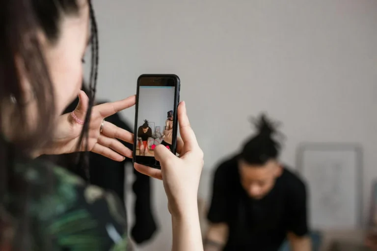 Cómo editar y publicar TikTok sin quemarte: tutorial de ritm... — Close-up of a person recording a video with a smartphone indoors, focusing on cr