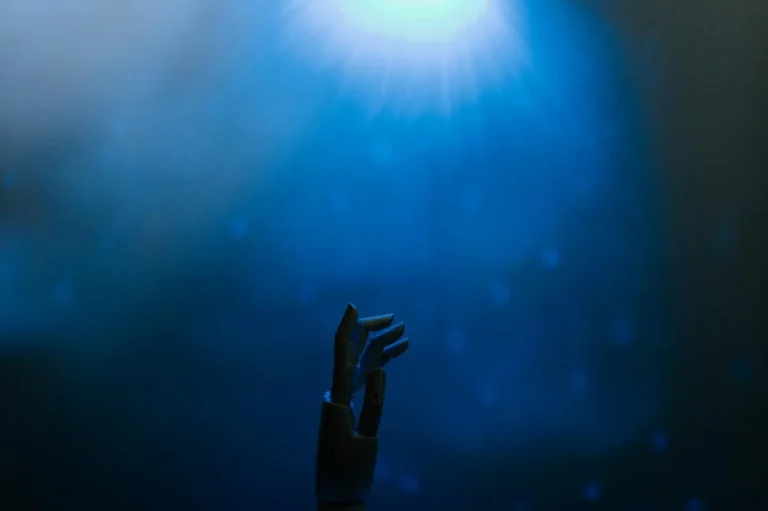 Cómo analizar documentos con Claude: tutorial paso a paso pa... — Silhouette of a robotic hand reaching towards glowing blue light in a futuristic