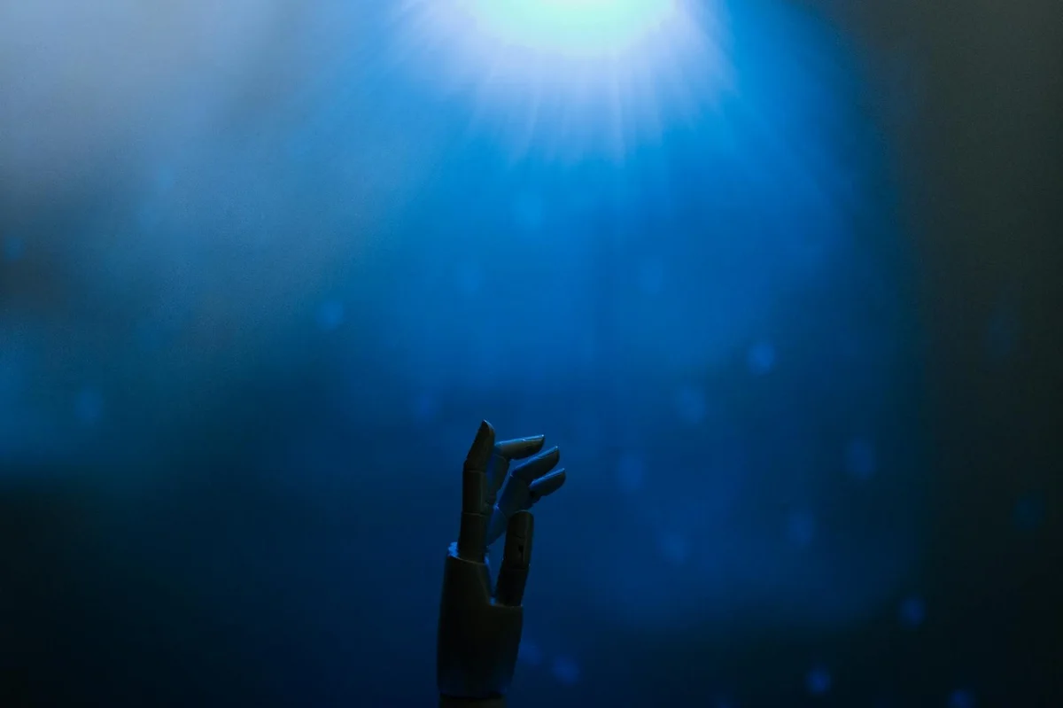 Cómo analizar documentos con Claude: tutorial paso a paso pa... — Silhouette of a robotic hand reaching towards glowing blue light in a futuristic