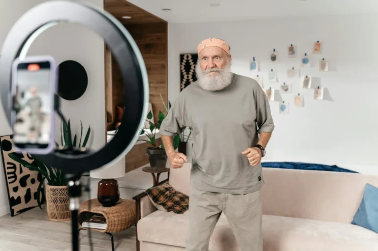 How to Script TikTok Videos Without Sounding Scripted: Step-... — Senior man dances for a social media video using a phone and ring light setup in