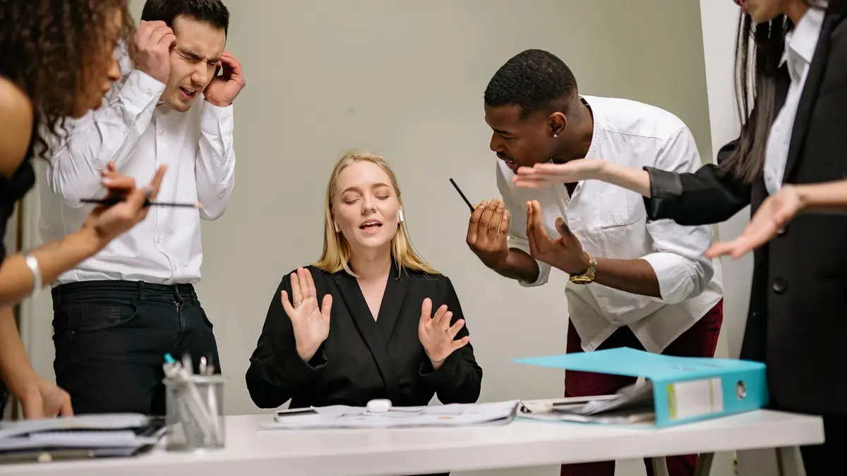 Diverse employees engaged in a heated discussion at a workplace meeting, showcasing stress and tensi