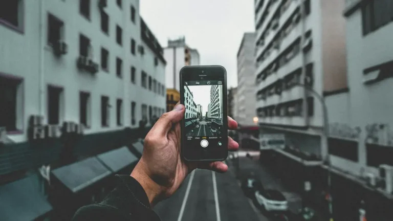A city street view captured through a smartphone, highlighting urban architecture and perspective.