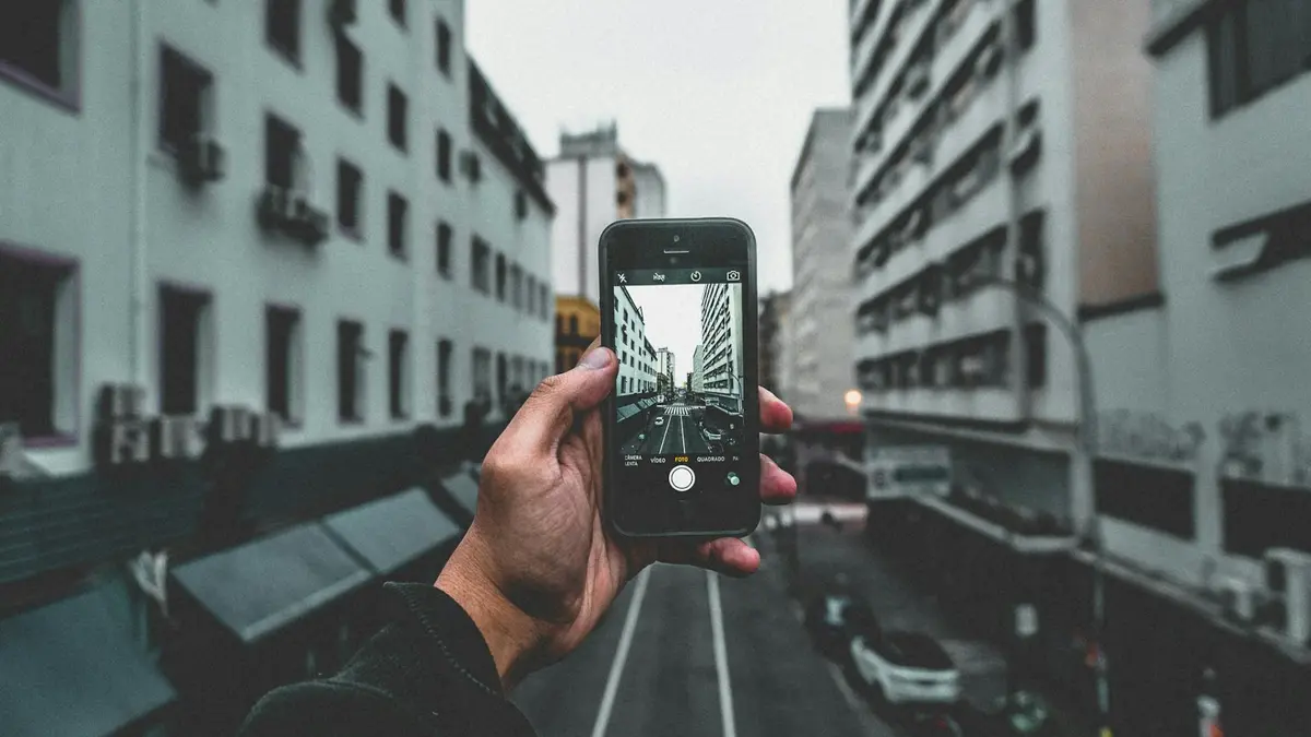 A city street view captured through a smartphone, highlighting urban architecture and perspective.